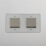Moderno interruptor basculante duplo em Níquel Polido Transparente Branco - Ferramenta de controlo de luz versátil em fundo branco